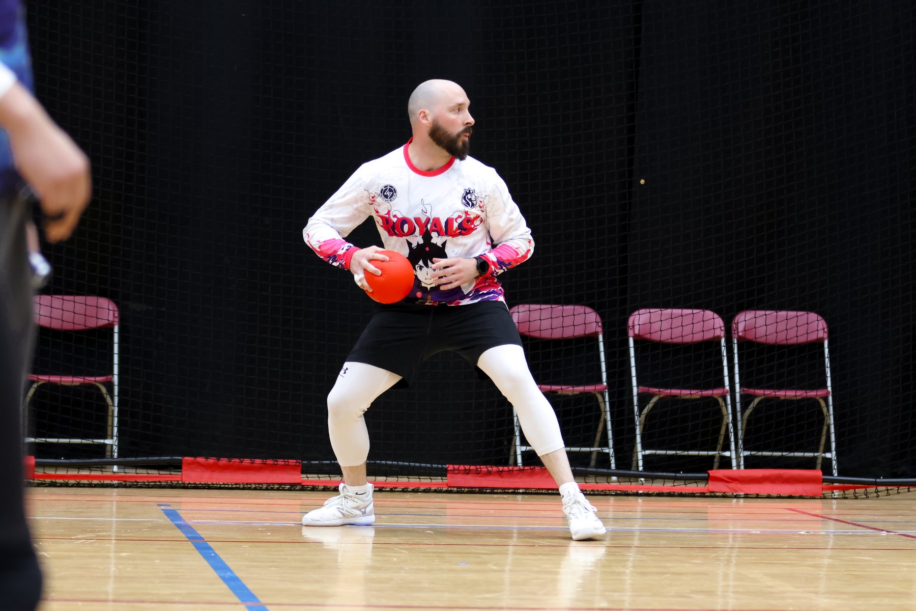 A dodgeball player holding a ball, set on court during a match